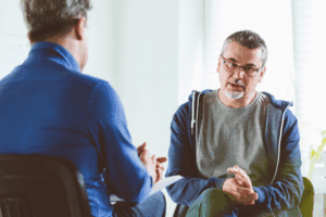 Two people sitting down and having a conversation about mental health